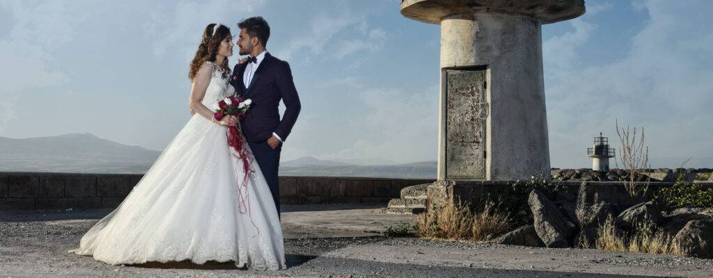 Blurred out image of a bride and groom looking into each others eyes on a beach front. Bold title text illustrates "weddings" and links to a wedding film page.